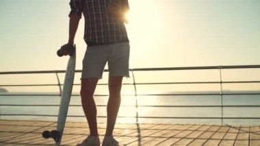 longboard tutarak ve smartphone yavaş hareket kullanarak yakışıklı erkek