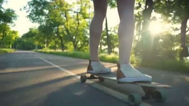 Κοντινό πλάνο αρσενικό πόδια στην κίνηση longboard σε πάρκο αργή κίνηση — Αρχείο Βίντεο