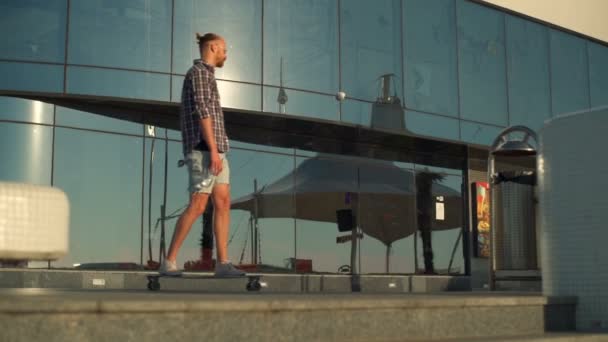 Przystojny mężczyzna jeździ longboard na ulicy, w pobliżu morza zwolnionym tempie — Wideo stockowe