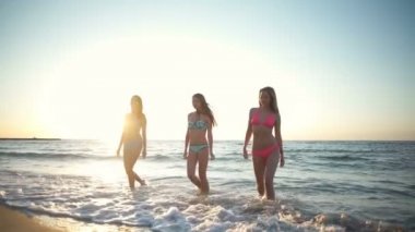 üç güzel genç kadın bikini deniz ağır çekim dışarı geliyor