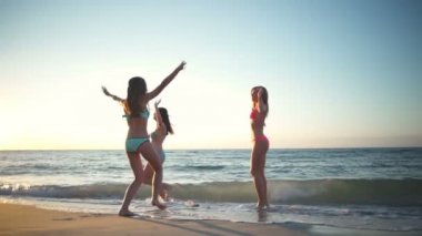 Kızlar mayo plaj yavaş hareket üzerinde eğleniyor