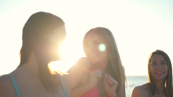 Nära håll glada tjejer i bikini promenader och pratar på stranden slow motion — Stockvideo