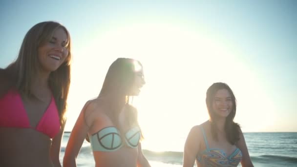 Fermer trois copines heureuses en bikini marcher le long de la mer au ralenti — Video