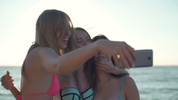 Primer plano feliz novias en bikini tomar selfie en la playa cámara lenta — Vídeos de Stock