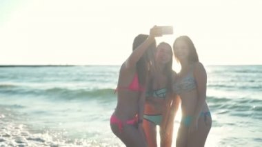 kızlar bikini plaj yavaş hareket güneş ışığı selfie alarak gülümseyen