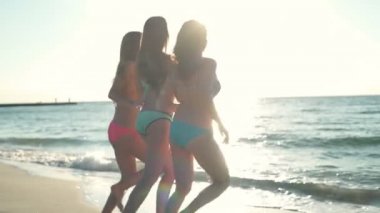 arkadan görünüşü deniz yavaş hareket çalışan üç mutlu kız bikini