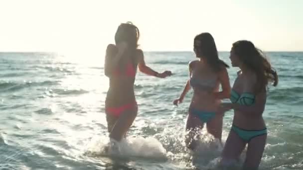 Três meninas alegres correndo para fora do mar câmera lenta — Vídeo de Stock