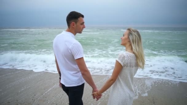 Romantisches Paar, das sich gegenseitig die Augen und das Meer in Zeitlupe betrachtet — Stockvideo