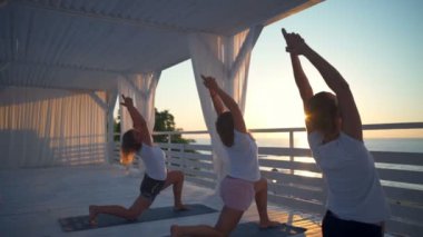 Arkadan Görünüm üç kadın pratik Yoga Teras yavaş hareket üzerinde