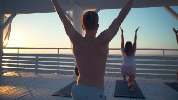 Bakifrån dolly skott av grupp yoga utomhus klass ultrarapid — Stockvideo