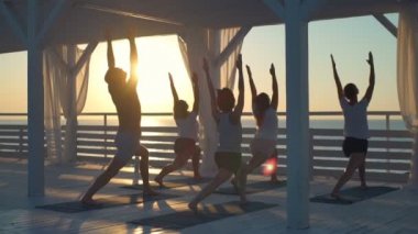 gençlerin pratik yoga açık havada şafak ağır çekim ışınları grup