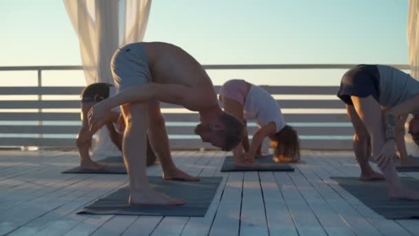 Dolly shot de yoga de groupe cours de plein air ralenti — Video