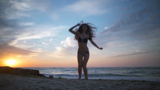 Happy mladá žena skákat nahoru a dolů na pláž Zpomalený pohyb — Stock video