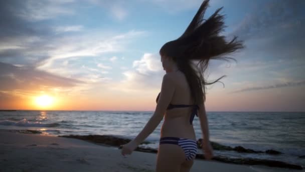 Vista trasera joven hembra en traje de baño corriendo a lo largo de la playa cámara lenta — Vídeos de Stock