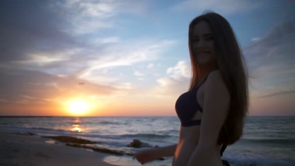 Rückansicht einer fröhlichen jungen Frau, die sich in Strandzeitlupe der Kamera zuwendet — Stockvideo
