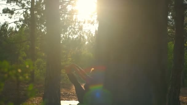 Lányok jóga napnyugtakor erdő Paripurna Navasana lassú mozgás — Stock videók