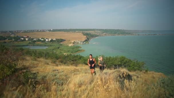 Deportiva pareja sonriendo trotando en la colina firth fondo cámara lenta — Vídeos de Stock