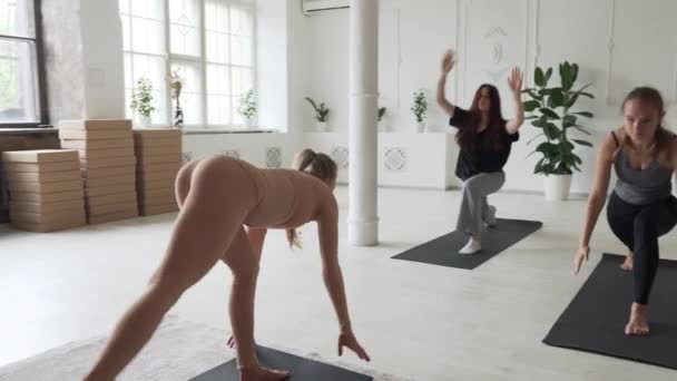 Jong aantrekkelijk vrouwen doen yoga in grote studio met instructeur — Stockvideo