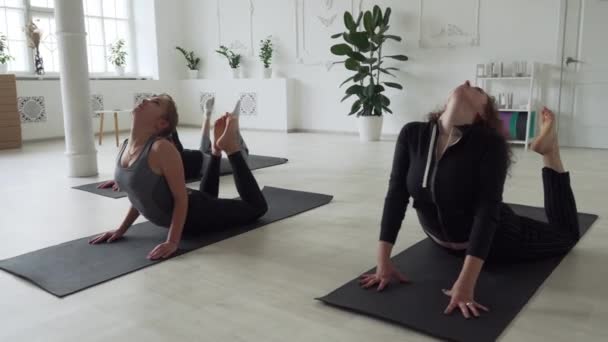 Bello yoga istruttore aiuto per il suo studente in classe asana — Video Stock