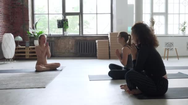 Grupo de estudiantes dando las gracias al profesor después de la clase de hatha yoga — Vídeos de Stock