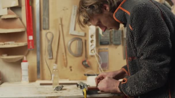 Jeune menuisier attrayant faire aiguiser son outil dans l'atelier — Video