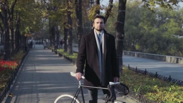 Joven empresario de pie con bicicleta — Vídeos de Stock
