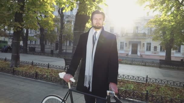 Porträtt av affärsman står nära sin cykel på hösten boulevard — Stockvideo