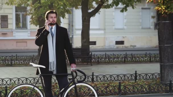 Affärsman står nära cykel prata i telefon — Stockvideo