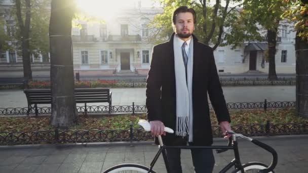 Porträtt av affärsman står nära sin cykel på hösten boulevard — Stockvideo