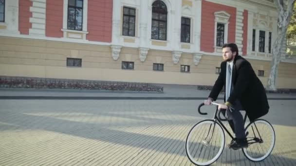 Hombre de negocios guapo montando una bicicleta en la ciudad vieja — Vídeos de Stock