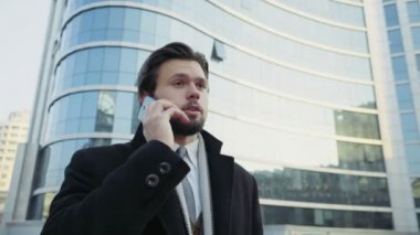yakışıklı işadamı şehir merkezinde telefonda konuşuyor