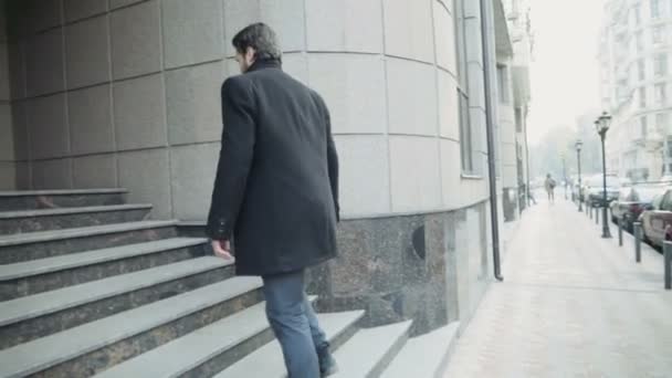 Красивый бизнесмен покидает здание бизнес-центра — стоковое видео