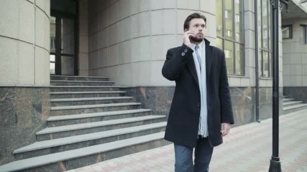 Hombre de negocios guapo hablando por teléfono en el centro de la ciudad — Vídeo de stock