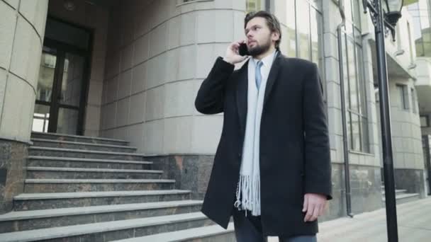 Hombre de negocios guapo hablando por teléfono en el centro de la ciudad — Vídeos de Stock