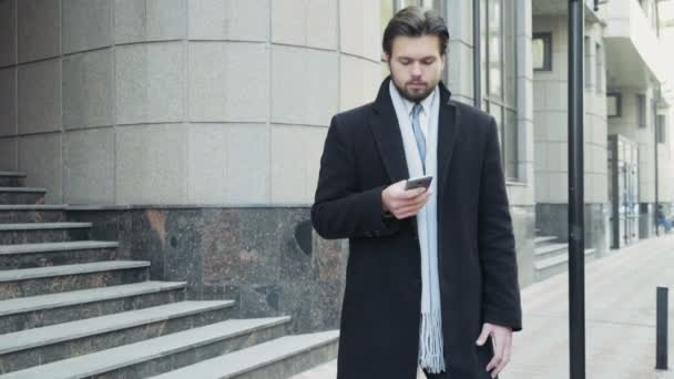 Handsome businessman using a smartphone in downtown — Stock Video