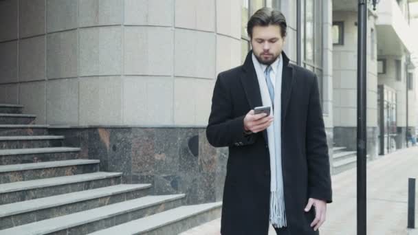 Hombre de negocios guapo hablando por teléfono en el centro de la ciudad — Vídeo de stock