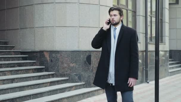 Hombre de negocios guapo hablando por teléfono en el centro de la ciudad — Vídeo de stock