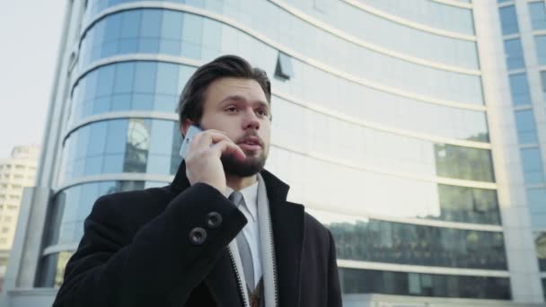 Hombre de negocios guapo hablando por teléfono en el centro de la ciudad — Vídeo de stock