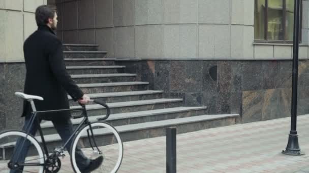 Bel homme d'affaires marchant avec son vélo dans le centre-ville — Video
