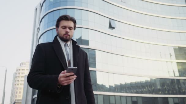 Красивий бізнесмен, використовуючи смартфон у центрі міста — стокове відео