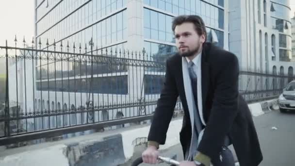 Knappe zakenman een fiets in centrum slow motion — Stockvideo