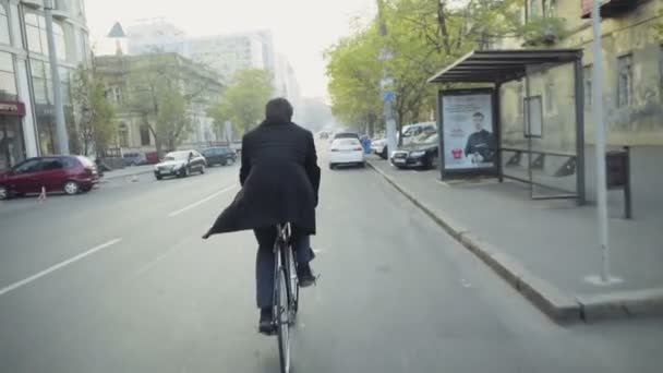 Knappe zakenman een fiets in centrum slow motion — Stockvideo