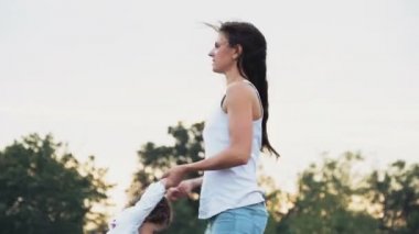 sonbahar alanında küçük kızıyla birlikte yuvarlak dönen anne