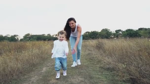 Bonita madre e hija caminando en el campo de otoño — Vídeo de stock