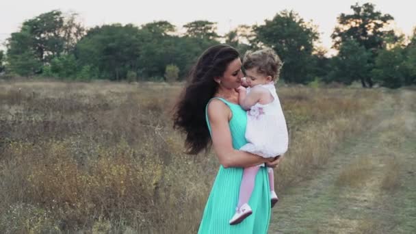Mutter hält ihre kleine Tochter auf dem Herbstfeld — Stockvideo