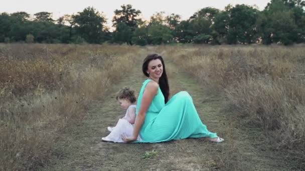 Мати і її маленька дочка відпочивають на осінньому полі — стокове відео