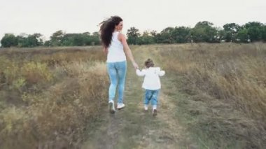 Anne ve küçük kızı kamera sonbahar sahada çalışan uzak