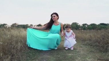 Anne ve küçük kızı onların elbiseleri sonbahar sahada gösterilen