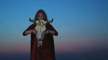 genç kadın boğa kafatası bir maske olarak koyarak bir cadı kostümü