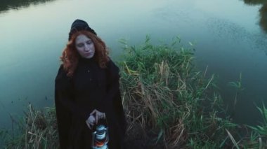 Göl kenarında bir lamba ayakta tutan eski moda elbise erkek giymiş